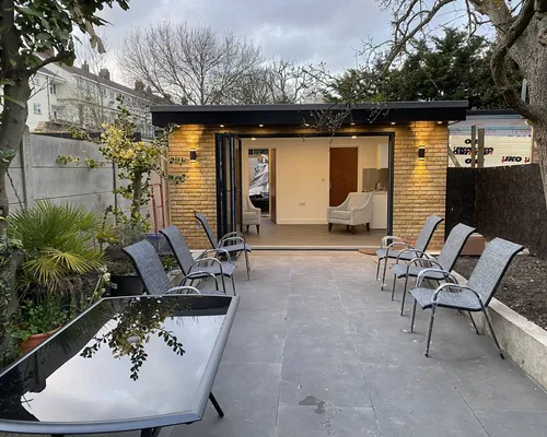 Garden room opening onto a paved terrace