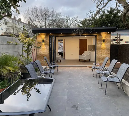 Garden room opening onto a paved terrace