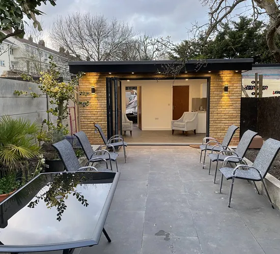 Garden room opening onto a paved terrace