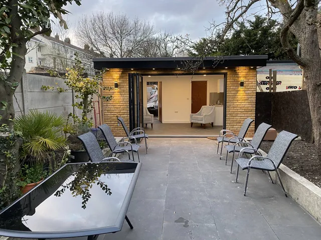 Garden room opening onto a paved terrace