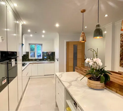 Kitchen with white cabinetry and brass pendant lighting