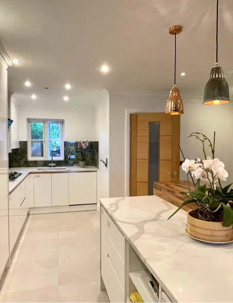 Kitchen with white cabinetry and brass pendant lighting