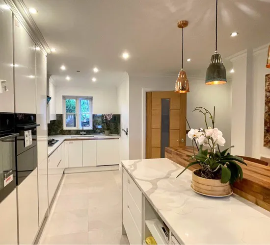 Kitchen with white cabinetry and brass pendant lighting