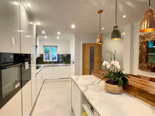 Kitchen with white cabinetry and brass pendant lighting